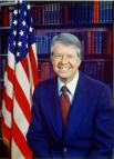 Jimmy Carter, head-and-shoulders portrait, facing front, next to an American flag